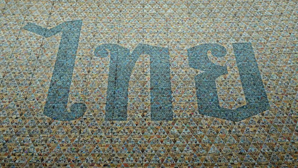 Le mot « ไทย », thai, composé d'une mosaïque de petits triangles multicolores : l'identité nationale écrite à partir d'une multitude de fragments. — © Eric Monteil Mot thaï « ไทย » (Thaï) en grandes lettres bleues formées par une mosaïque de triangles colorés.